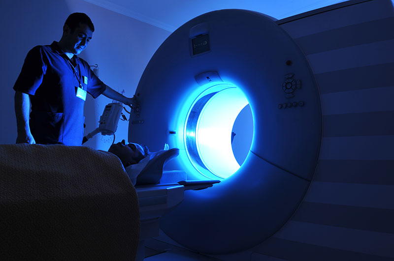 A person putting a person into a MRI